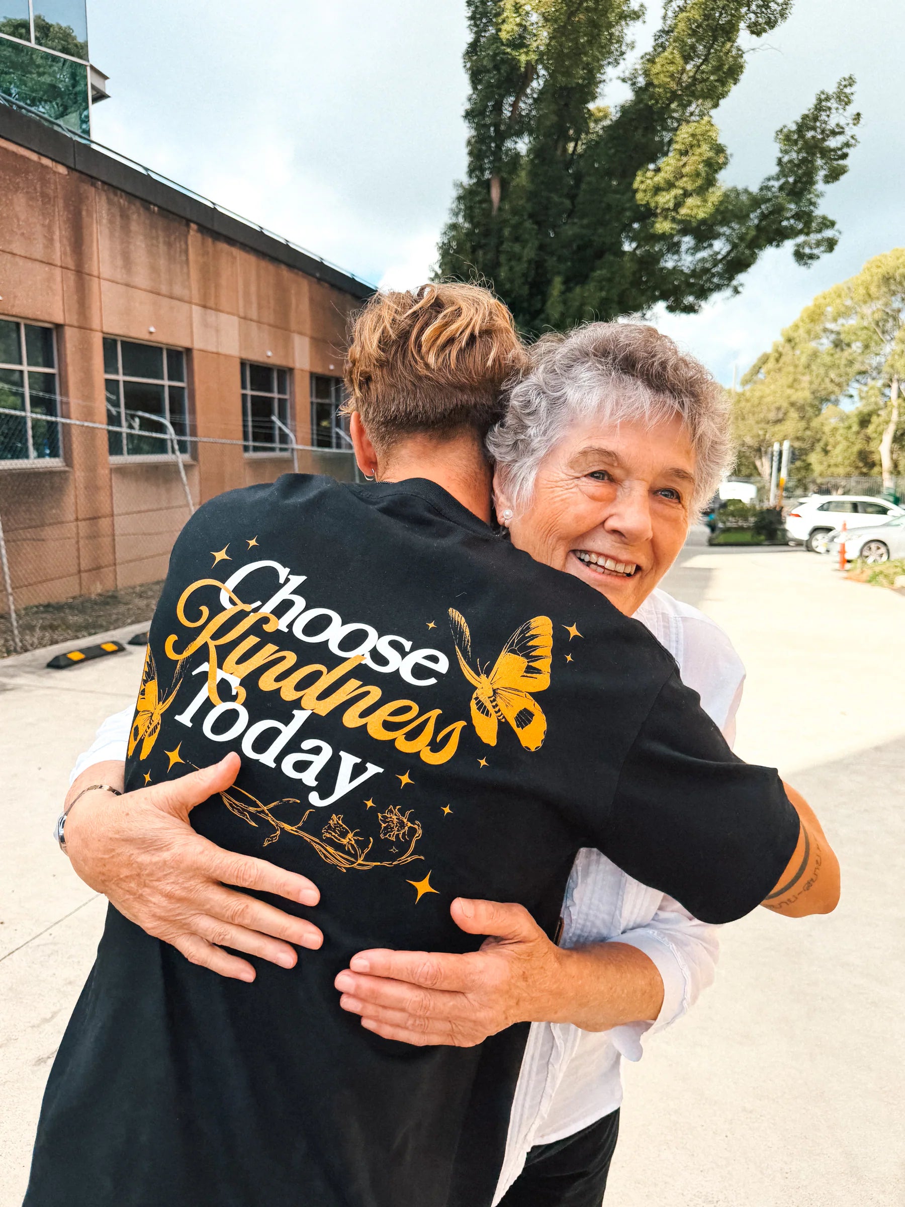 Lee embracing Pam after sharing her story with the Butterfly community